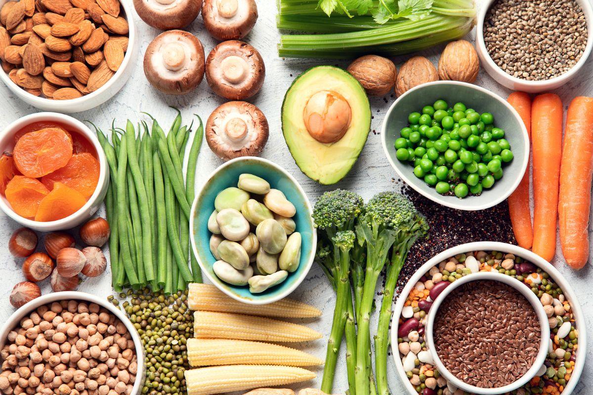 plant-based food on a table - mushrooms, almonds, celery, seeds, nuts, beans, broccolini, corn